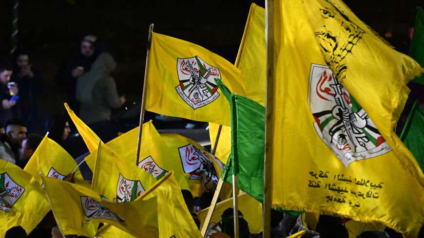 Palestinians wave yellow flags of Fatah group as they wait for the release of prisoners in exchange for Israeli hostages held by Hamas, in Ramallah on Nov. 27, 2023.